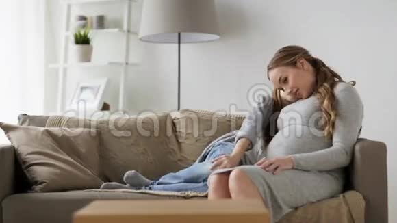快乐的孕妇和坐在沙发上的女孩视频的预览图