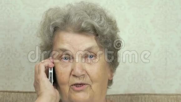老妇人在家里说智能手机视频的预览图