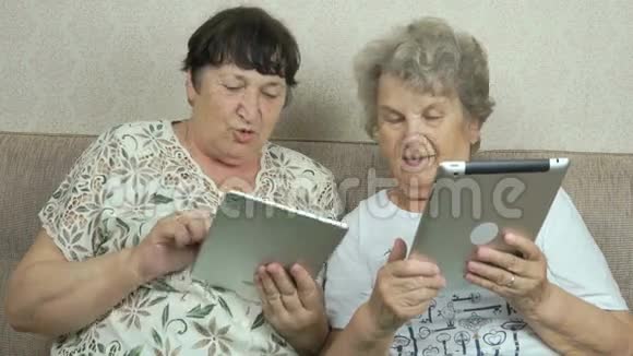 老年妇女拿着银色数码平板电脑视频的预览图