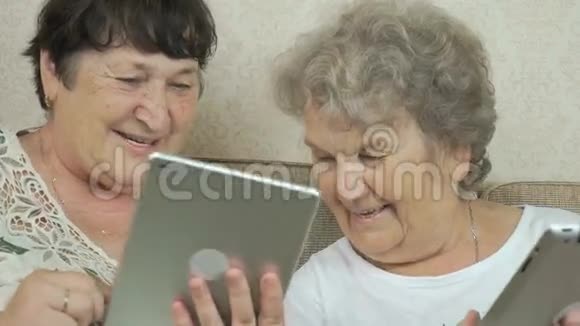 老年妇女拿着银色数码平板电脑视频的预览图