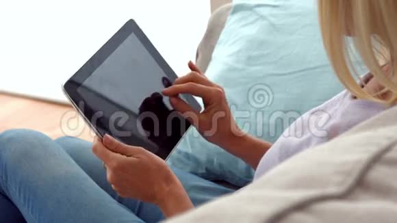 女人在沙发上用平板电脑视频的预览图
