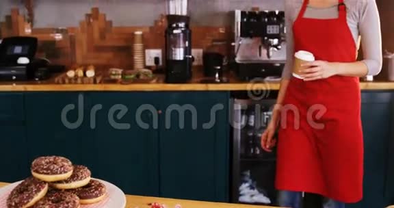 微笑的女服务生在柜台端上一杯咖啡视频的预览图