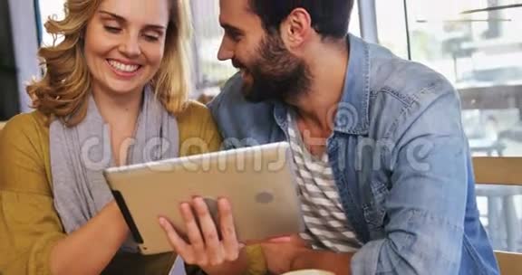 一对夫妇在咖啡A使用数字平板电脑视频的预览图
