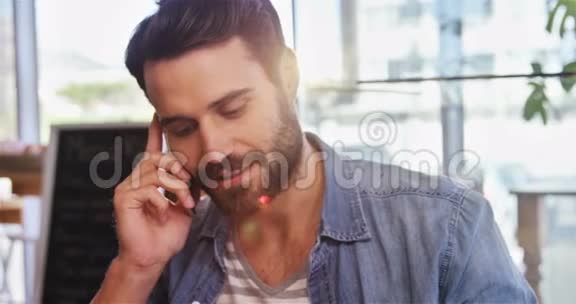 男人一边喝咖啡一边用手机说话视频的预览图