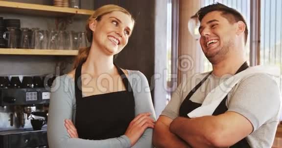微笑的侍者和站着的女服务员交叉着手臂视频的预览图