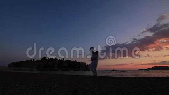 日落时分一对新婚夫妇在海上的剪影婚礼在视频的预览图