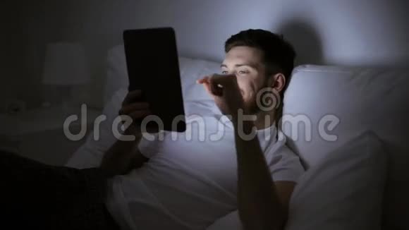 带平板电脑的年轻人在家卧室的床上视频的预览图