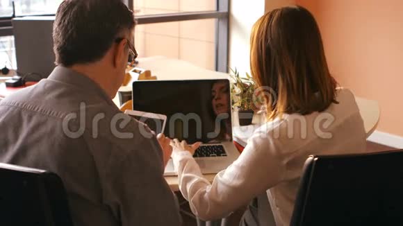 使用数码平板电脑和笔记本电脑的商界人士视频的预览图