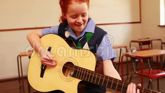 可爱的学生在教室里弹吉他视频的预览图