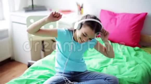 戴耳机的女孩在家听音乐视频的预览图