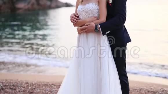 新郎在海滩上拥抱新娘黑山婚礼视频的预览图