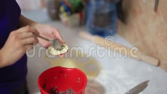 她在厨房里雕刻饺子烹饪食物视频的预览图