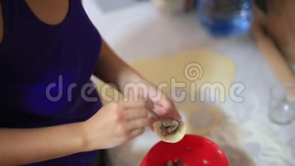 她在厨房里雕刻饺子烹饪食物视频的预览图