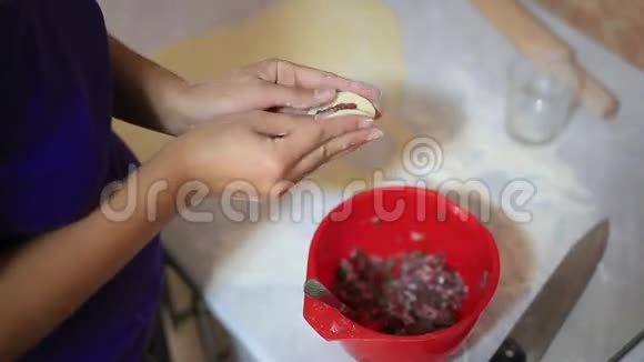 她在厨房里雕刻饺子烹饪食物视频的预览图