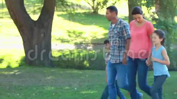 幸福的一家人在公园里散步视频的预览图