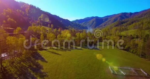 在阳光明媚的夏日早晨中气飞越新鲜的山河和草地农村土路下面视频的预览图