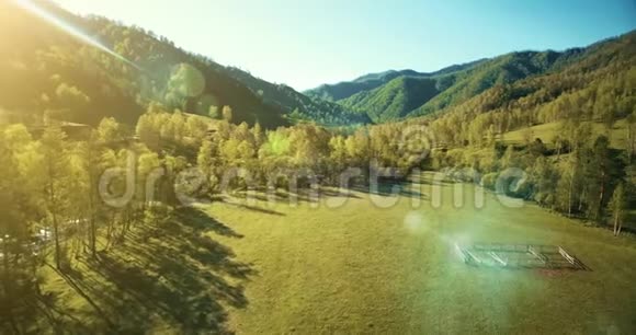 超高清4K鸟瞰图在阳光明媚的夏季早晨低飞过新鲜寒冷的山河草地和道路视频的预览图