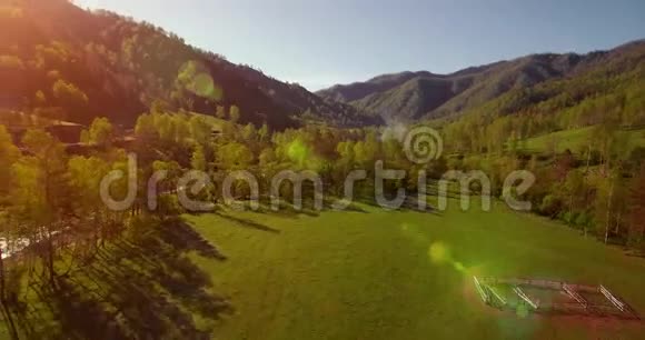 在阳光明媚的夏日早晨中气飞越新鲜的山河和草地农村土路下面视频的预览图