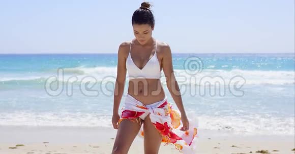穿比基尼站在沙滩上的年轻女子视频的预览图