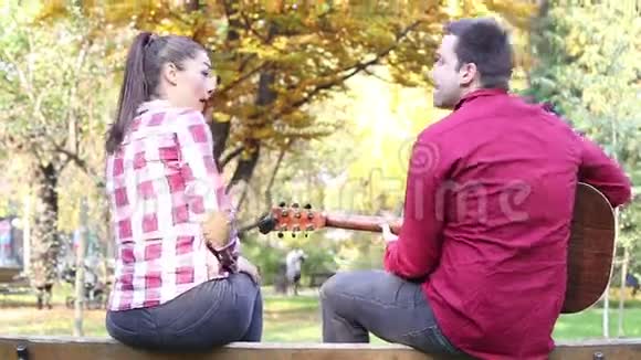男人弹吉他女人在公园唱歌视频的预览图