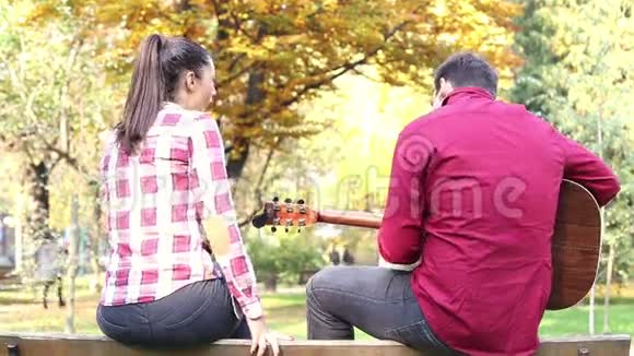 男人弹吉他女人在公园唱歌视频的预览图