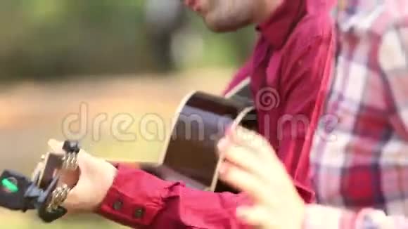 年轻的黑发女人唱歌而男人坐在她旁边弹吉他视频的预览图