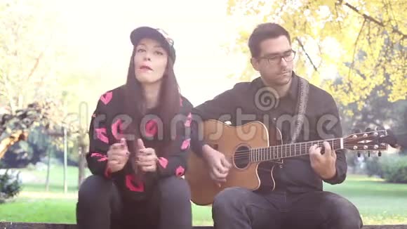 年轻人弹吉他而美女坐在他旁边视频的预览图