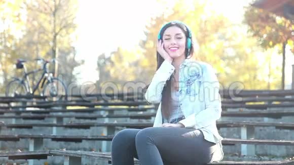公园里戴着耳机听音乐的美女视频的预览图