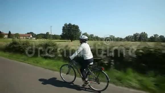 女人在农村的路上骑自行车视频的预览图