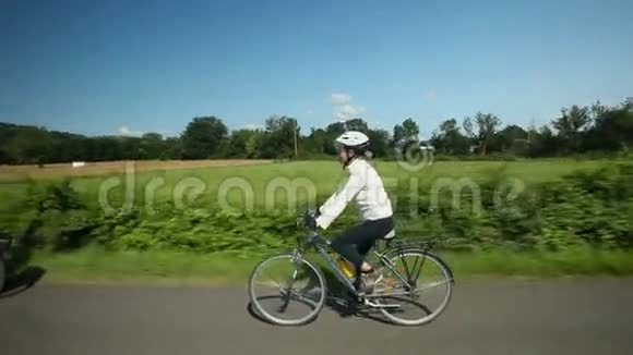 慢动作女子骑自行车上路视频的预览图
