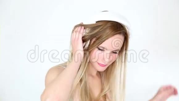 美丽的金发女郎戴着白色耳机跳舞视频的预览图