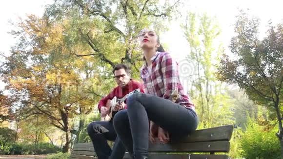 公园里男人弹吉他时美女唱歌视频的预览图