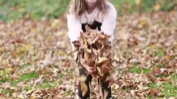 可爱的女孩在公园里扔树叶视频的预览图