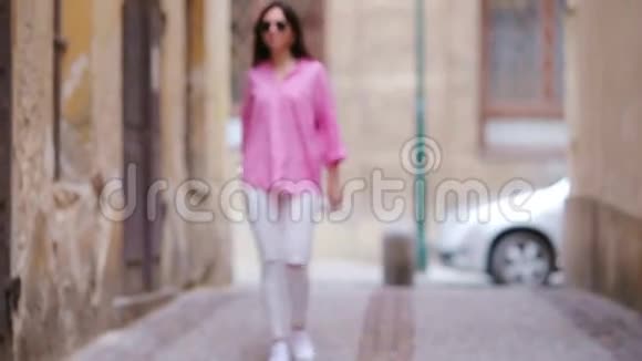 欧洲城市快乐的年轻都市女性白人游客沿着欧洲荒芜的街道散步视频的预览图