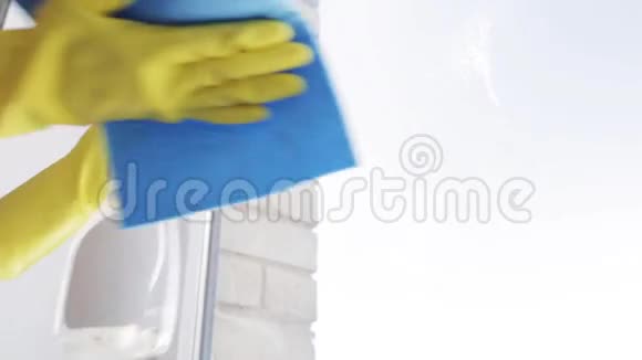 戴手套的女人用抹布擦窗户视频的预览图