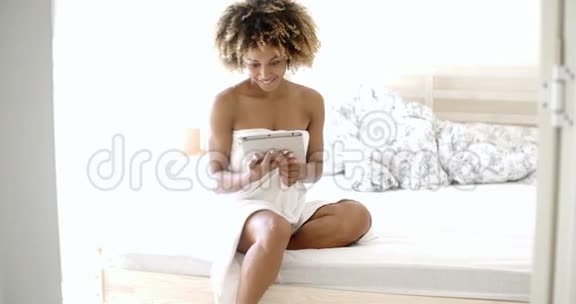 在床上用平板电脑的年轻女人视频的预览图