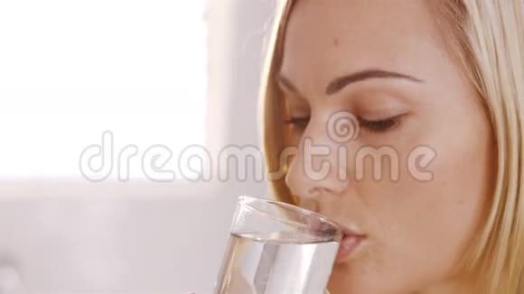 金发女人喝着一杯水视频的预览图