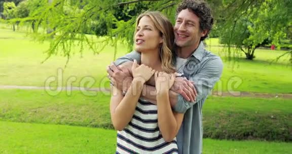 微笑的情侣拥抱在公园里视频的预览图