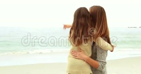 妈妈和女儿在看海滩视频的预览图