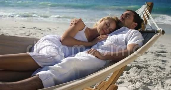在海滩的吊床上放松的情侣视频的预览图