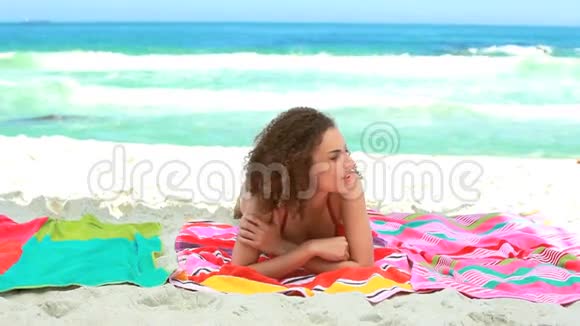 女人躺在沙滩毛巾上视频的预览图