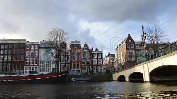 在阿姆斯特丹从运河到街道拥有古老的弗拉米什房屋和桥梁的运河的慢镜头视频视频的预览图