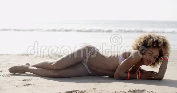 比基尼女人躺在热带海滩上视频的预览图