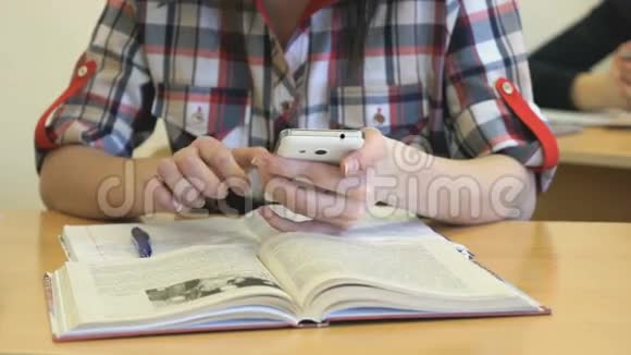 坐在办公桌前的女学生在笔记本上写课文视频的预览图
