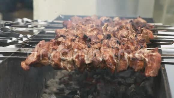 肉是在煤块上的金属串上准备的视频的预览图