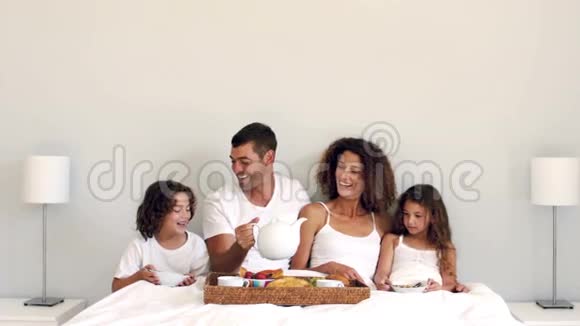 可爱的家人在床上吃早餐视频的预览图