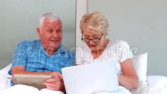 年长夫妇使用平板电脑和笔记本电脑视频的预览图