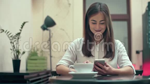 在咖啡厅使用智能手机的女性视频的预览图