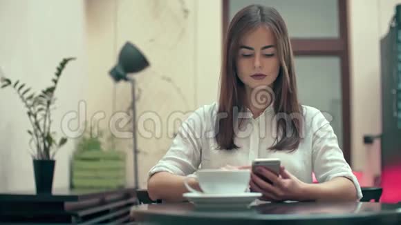 在咖啡厅使用智能手机的女性视频的预览图