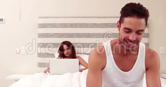 男人发短信女人用笔记本电脑视频的预览图